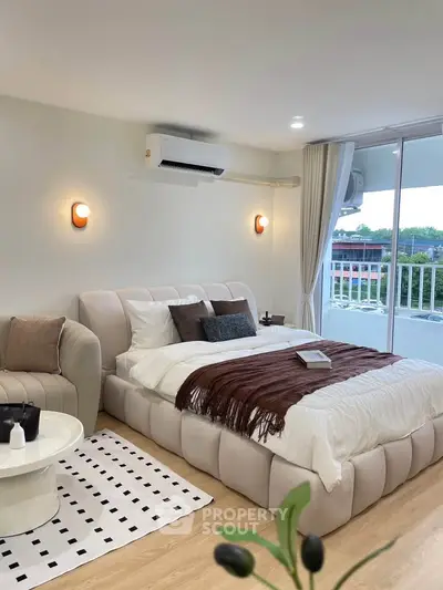 Modern bedroom with stylish decor and balcony view, featuring cozy bed and elegant lighting.