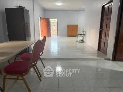 Spacious open-plan living area with tiled flooring and natural light