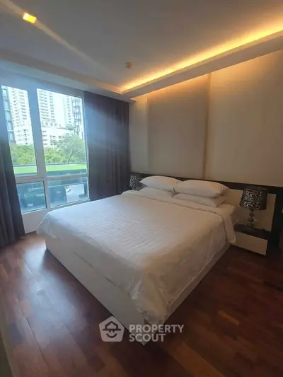 Modern bedroom with large window and stylish decor in urban apartment