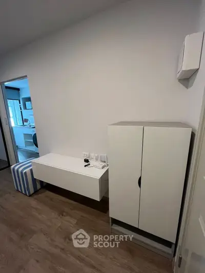 Modern interior with sleek white furniture and wooden flooring in a stylish apartment.