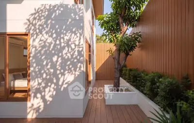 Modern exterior with wooden deck and lush greenery in a serene courtyard setting.