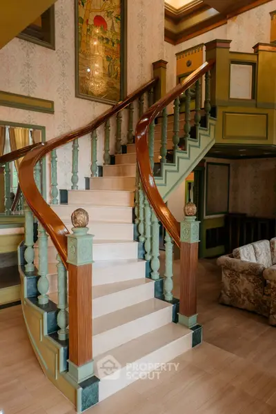 Elegant staircase with wooden railings in a luxurious living room setting.