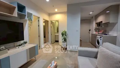 Modern living room with open kitchen and washing machine, stylish decor and cozy ambiance.