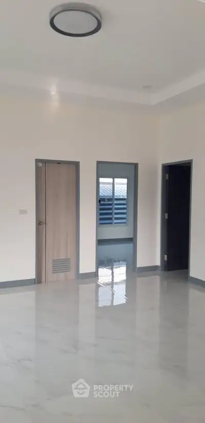 Spacious empty room with glossy marble flooring and modern lighting