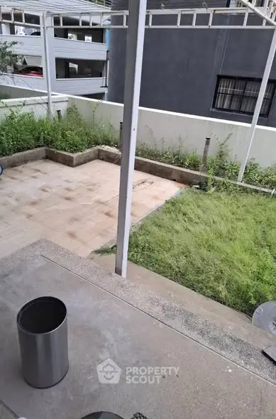 Spacious outdoor patio with lush greenery and modern design, perfect for relaxation and entertainment.