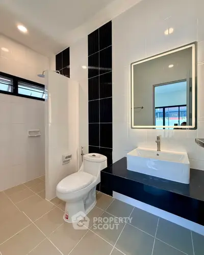 Modern bathroom with sleek fixtures and stylish black and white tile design.