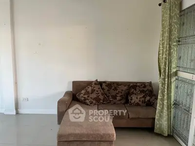 Cozy living room with a comfortable sofa and stylish curtains, perfect for relaxation.