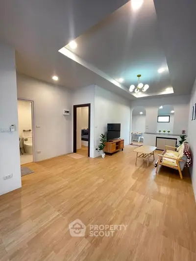 Spacious modern living room with wooden flooring and stylish lighting