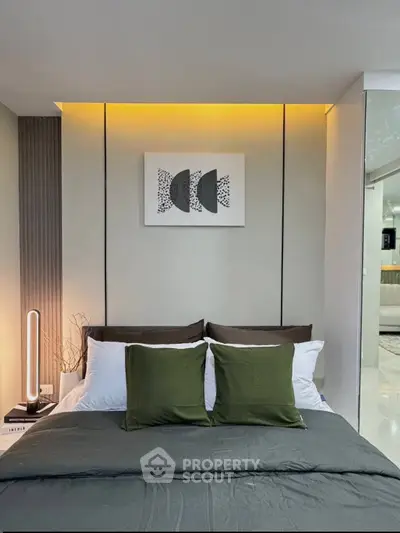Modern bedroom with stylish decor and ambient lighting, featuring a cozy bed with green accents.