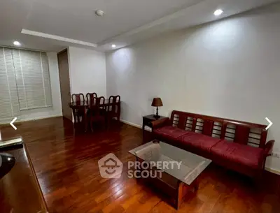 Spacious living room with wooden flooring and elegant furniture in modern apartment.