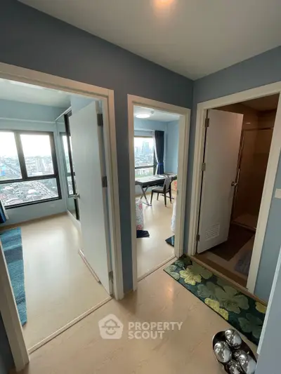 Spacious apartment hallway with multiple rooms and city view, showcasing modern interior design.