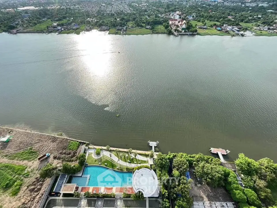 Stunning aerial view of riverside property with pool and lush greenery