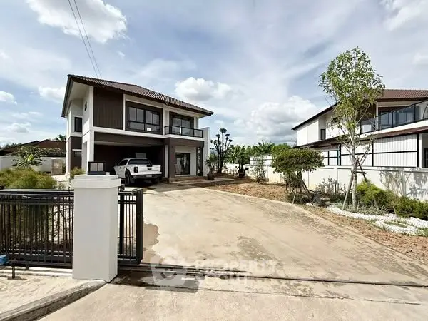 Modern two-story house with driveway and landscaped garden in suburban setting.