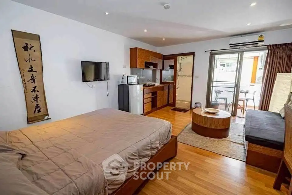 Spacious studio apartment with modern kitchen and cozy living area, perfect for urban living.