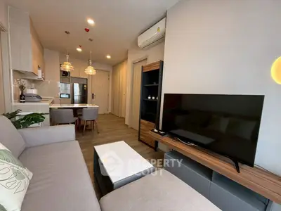 Modern living room with open kitchen, stylish decor, and cozy ambiance.