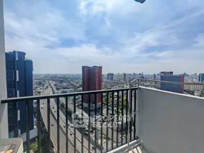 Stunning cityscape view from a high-rise balcony overlooking urban skyline and highway.