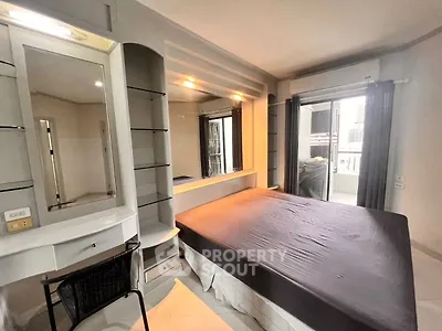 Modern bedroom with sleek built-in furniture and large window for natural light.