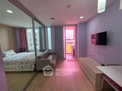 Modern studio apartment with mirrored wall and cozy furnishings