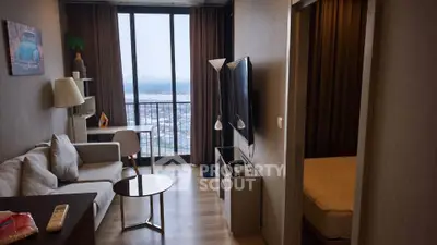 Modern living room with city view, stylish decor, and cozy ambiance in a high-rise apartment.