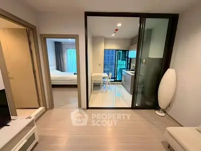 Modern apartment interior with open living area and kitchen, featuring sleek design and natural light.