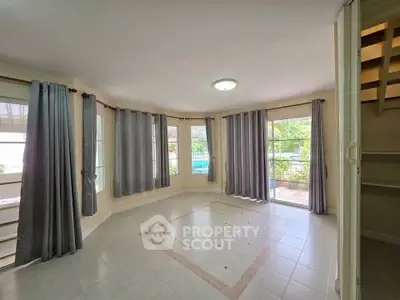 Spacious living room with large windows and elegant tile flooring