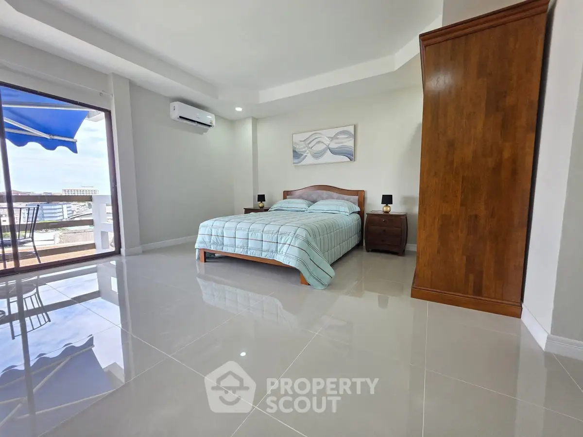 Spacious bedroom with modern decor and balcony access offering stunning views.