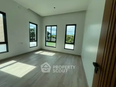 Spacious and bright room with large windows offering scenic views, perfect for a serene living space.