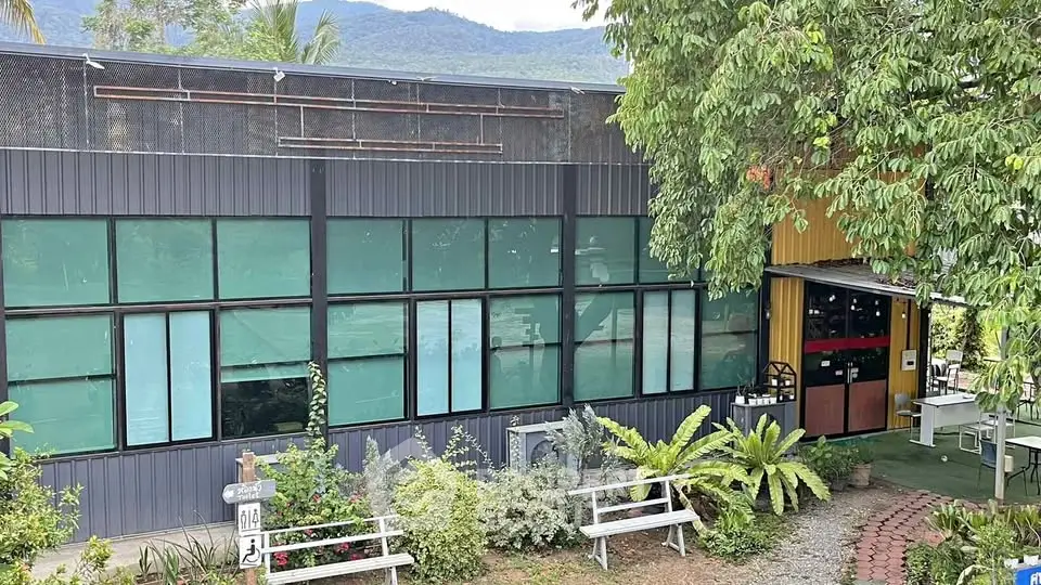 Modern building exterior with large windows and lush greenery, ideal for commercial or residential use.