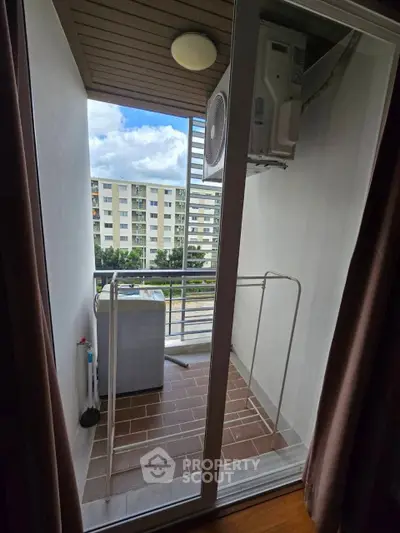 Charming balcony with laundry area and scenic view in modern apartment.