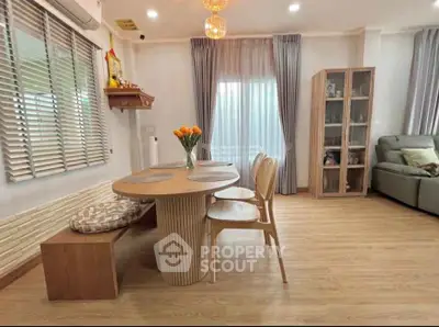 Charming living room with modern decor, wooden flooring, and elegant dining area, perfect for cozy gatherings.