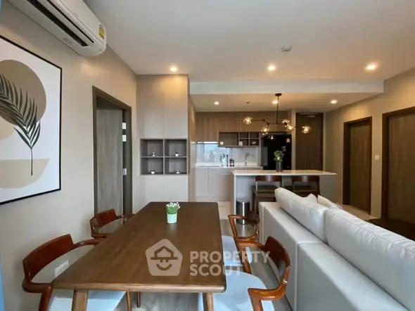 Modern open-plan living room and kitchen with stylish dining area and contemporary decor.