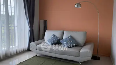 Cozy living room with modern sofa and floor lamp, featuring large windows and elegant curtains.