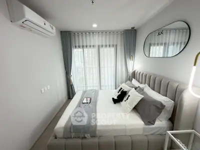 Modern bedroom with stylish decor and natural light, featuring a cozy bed and elegant curtains.