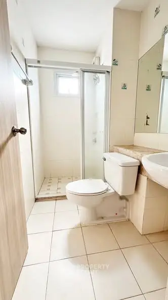 Modern bathroom with shower and sleek fixtures in a bright, tiled space.