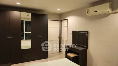 Spacious bedroom with modern furniture and air conditioning, ideal for comfortable living.