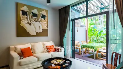 Stylish living room with elegant decor and garden view, featuring cozy seating and vibrant artwork.