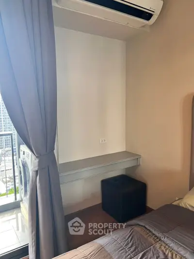 Modern bedroom with balcony view and air conditioning, featuring a cozy bed and stylish decor.