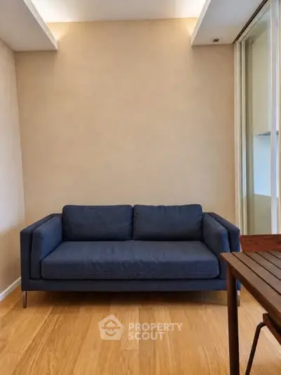 Modern living room with stylish blue sofa and wooden flooring, perfect for cozy relaxation.