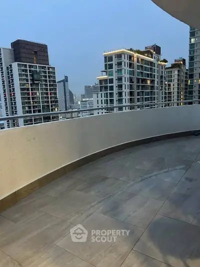 Spacious balcony with stunning cityscape views in modern high-rise building.