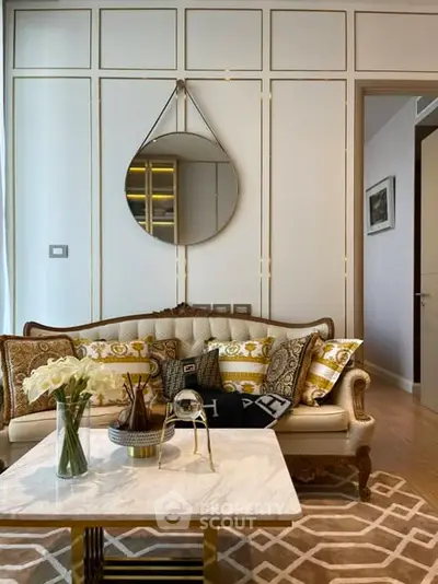 Luxurious living room with elegant sofa, stylish decor, and chic mirror accent.