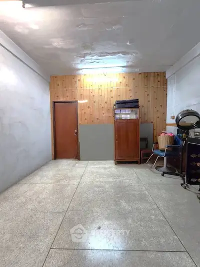 Spacious room with wooden paneling and vintage furniture, ideal for creative use.