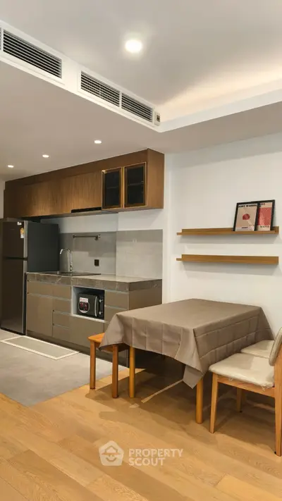 Modern kitchen with dining area, featuring sleek cabinetry and stylish decor.