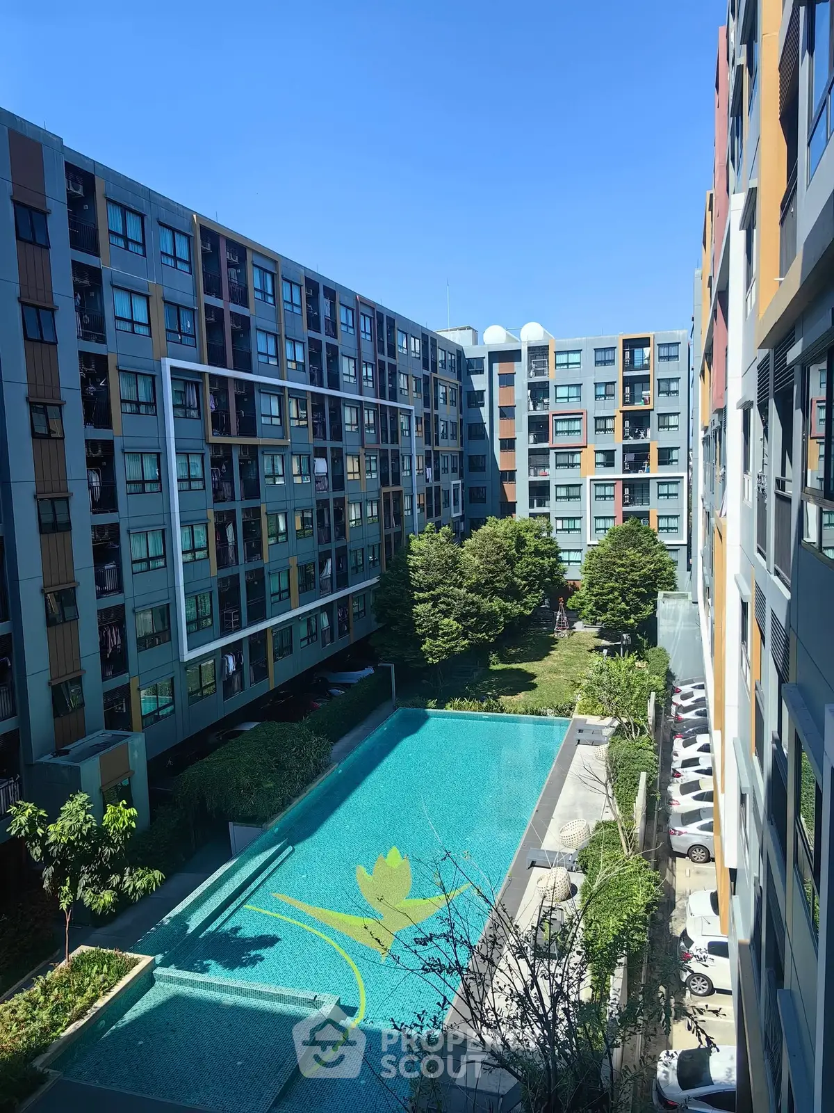Modern apartment complex with pool and lush greenery, perfect for urban living.