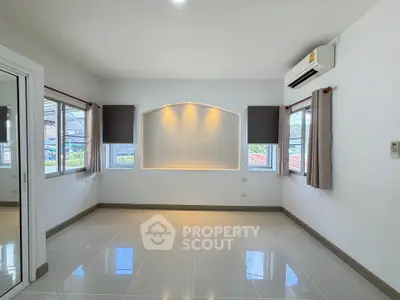 Spacious unfurnished room with large windows and air conditioning, perfect for customization.