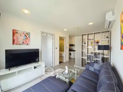 Modern living room with stylish decor and open layout, featuring a cozy sofa and entertainment center.