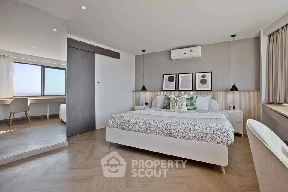 Modern bedroom with stylish decor and large window offering natural light