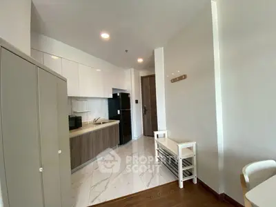 Modern kitchen with sleek cabinetry and marble flooring in a stylish apartment.