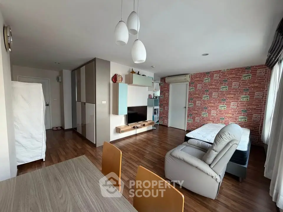 Spacious living room with modern decor and wooden flooring in a stylish apartment.