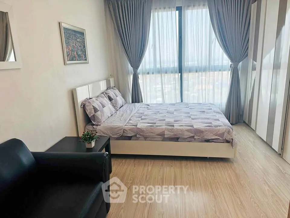 Bright and cozy bedroom with modern decor and large window view.