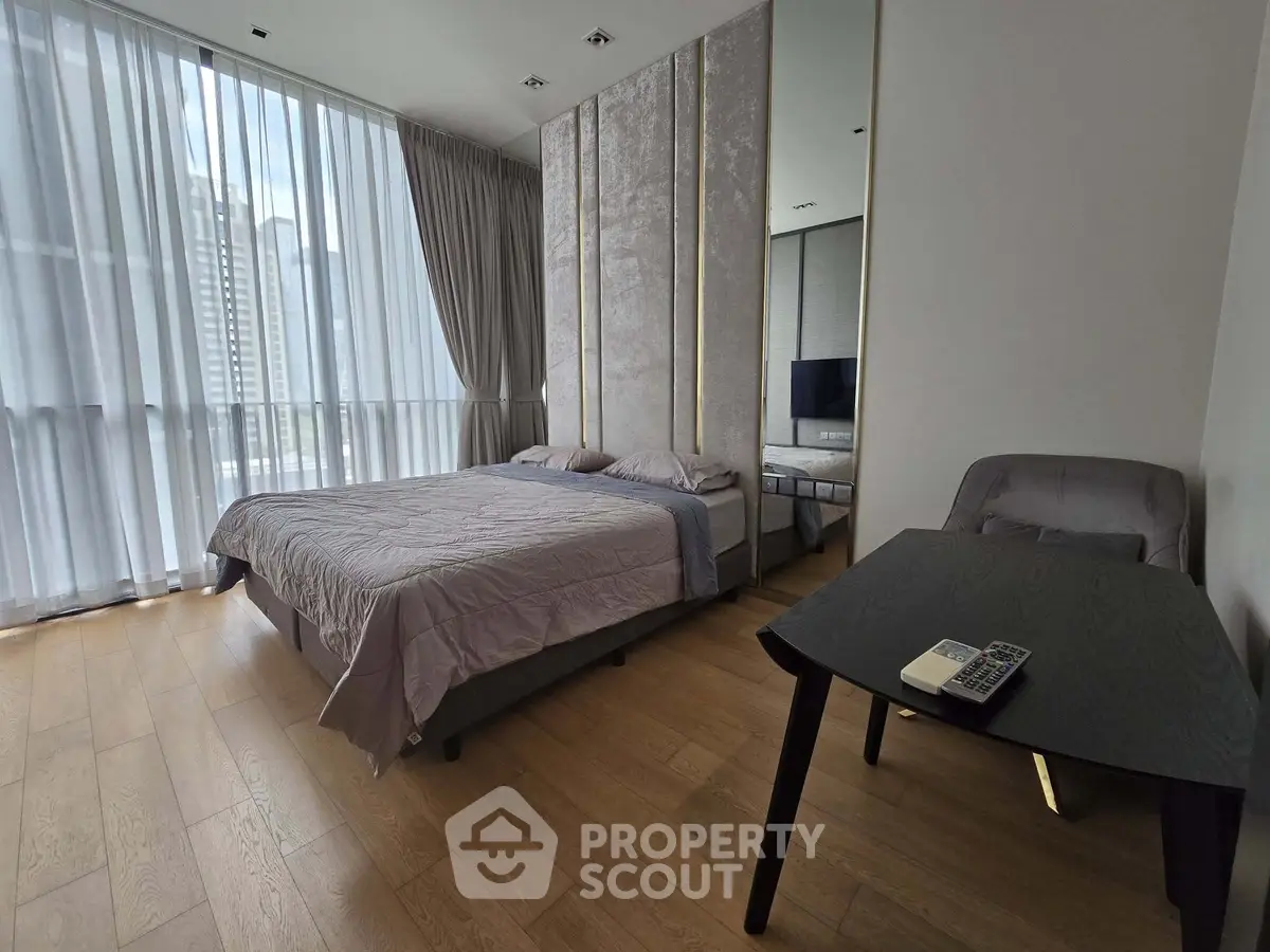 Spacious modern bedroom with floor-to-ceiling windows and elegant decor in a high-rise apartment.
